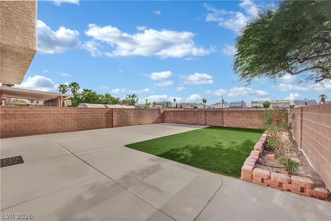 5823 Golden Wing Street, Las Vegas, NV 89113 A well-maintained concrete patio provides ample outdoor living space, complemented by a patch of artificial turf and a private yard.