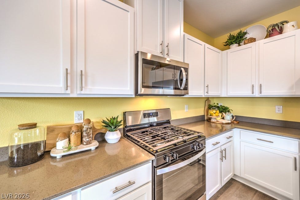 1090 Saffron Toucan Lane, Henderson, NV 89011 Kitchen featuring stainless steel appliances, white cabinetry, and dark stone counters. Home is representational only; actual home finishes may vary.