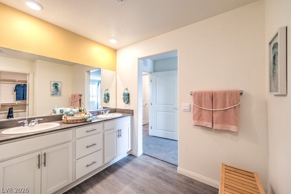 1090 Saffron Toucan Lane, Henderson, NV 89011 Full bathroom with double vanity and light wood-style floors. Home is representational only; actual home finishes may vary.