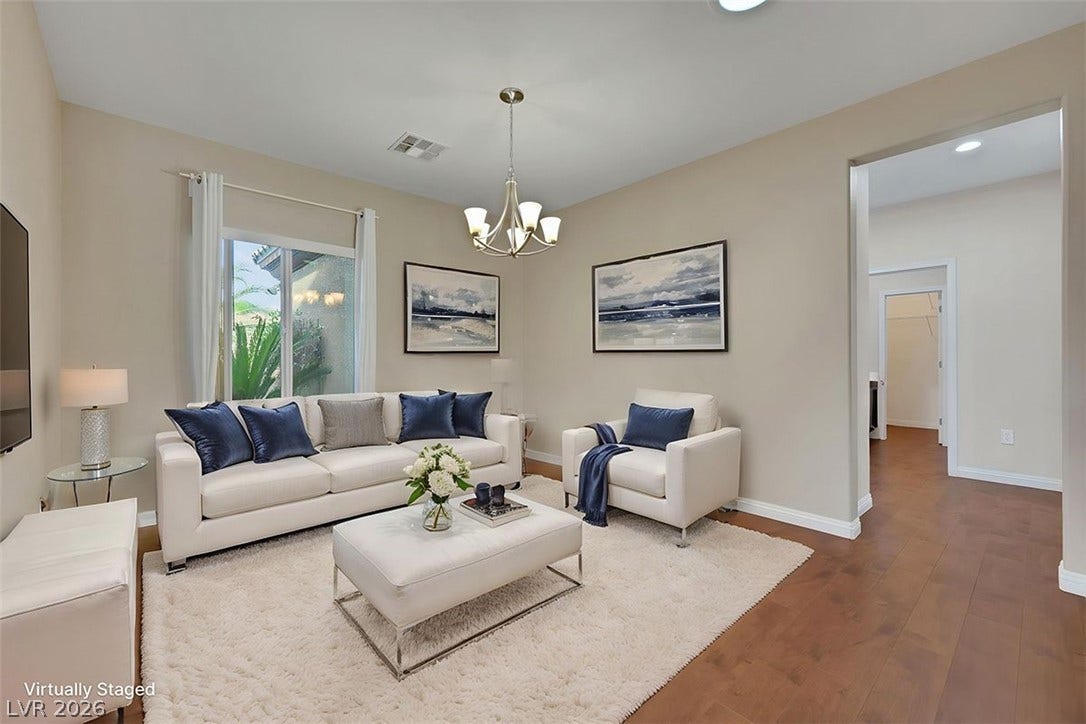 A well-lit gathering space offers rich wood floors and a contemporary light fixture, ideal for entertaining.