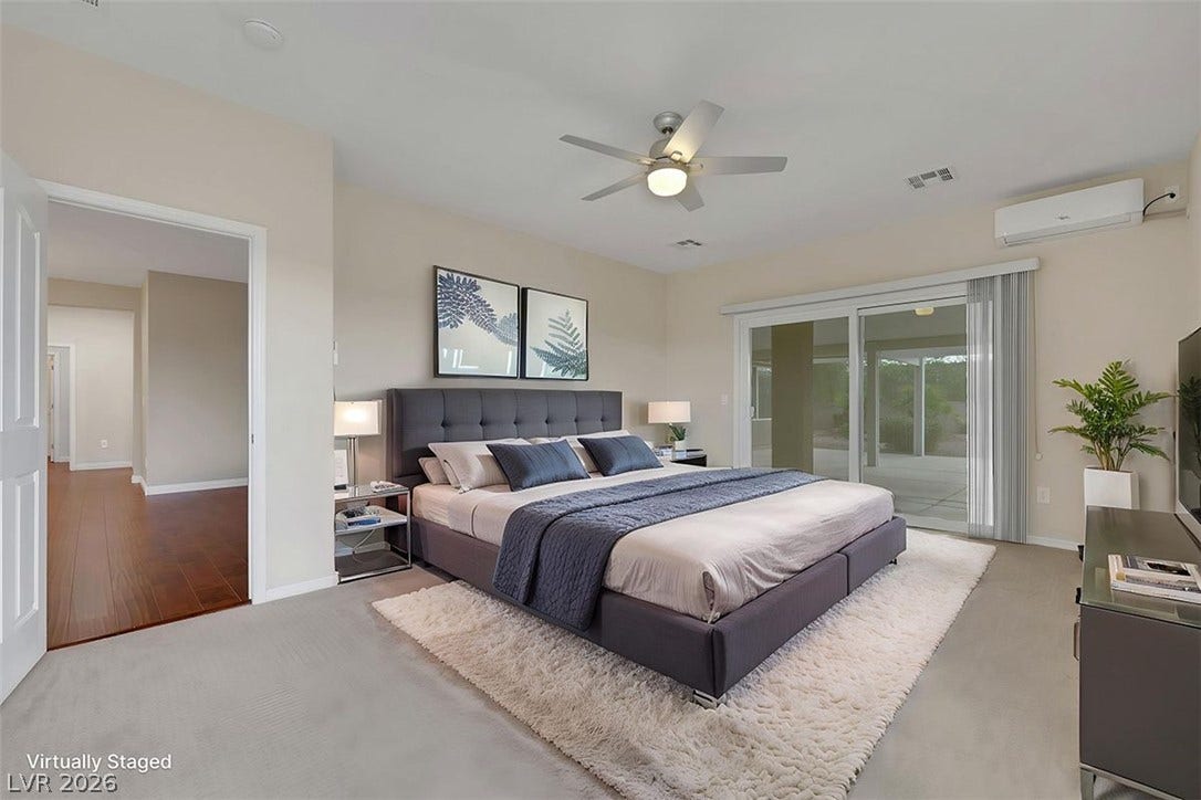 Step into a serene primary bedroom featuring a ceiling fan and direct access to an outdoor patio through sliding glass doors.
