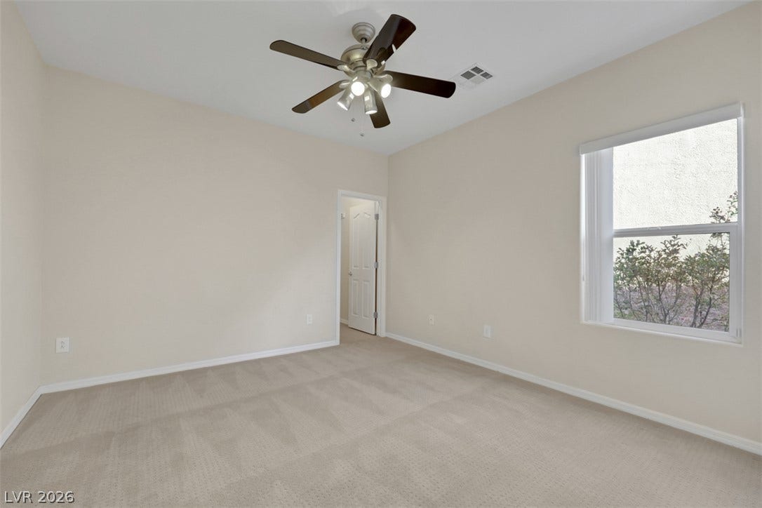 A well-proportioned bedroom with a large window and a contemporary ceiling fan offers comfortable living.