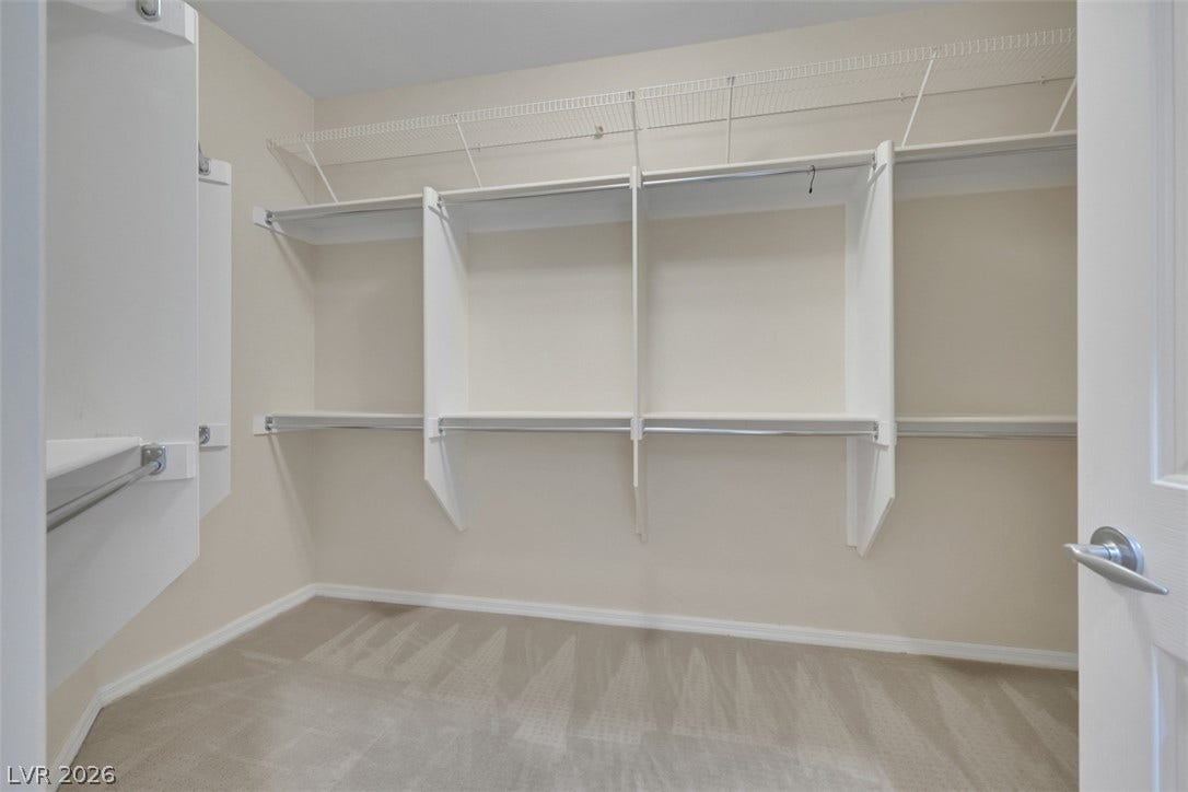 Ample shelving and hanging space in this well-organized walk-in closet.