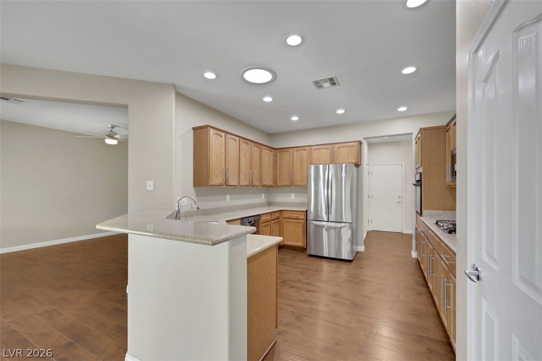 A well-appointed kitchen features warm cabinetry, granite countertops, and modern stainless steel appliances.