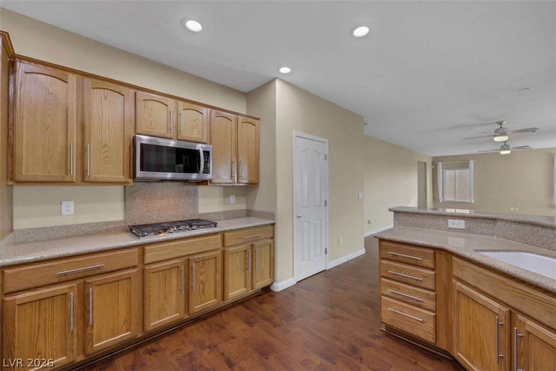 A well-appointed kitchen features rich wood cabinetry and ample counter space, seamlessly connecting to an inviting living area.