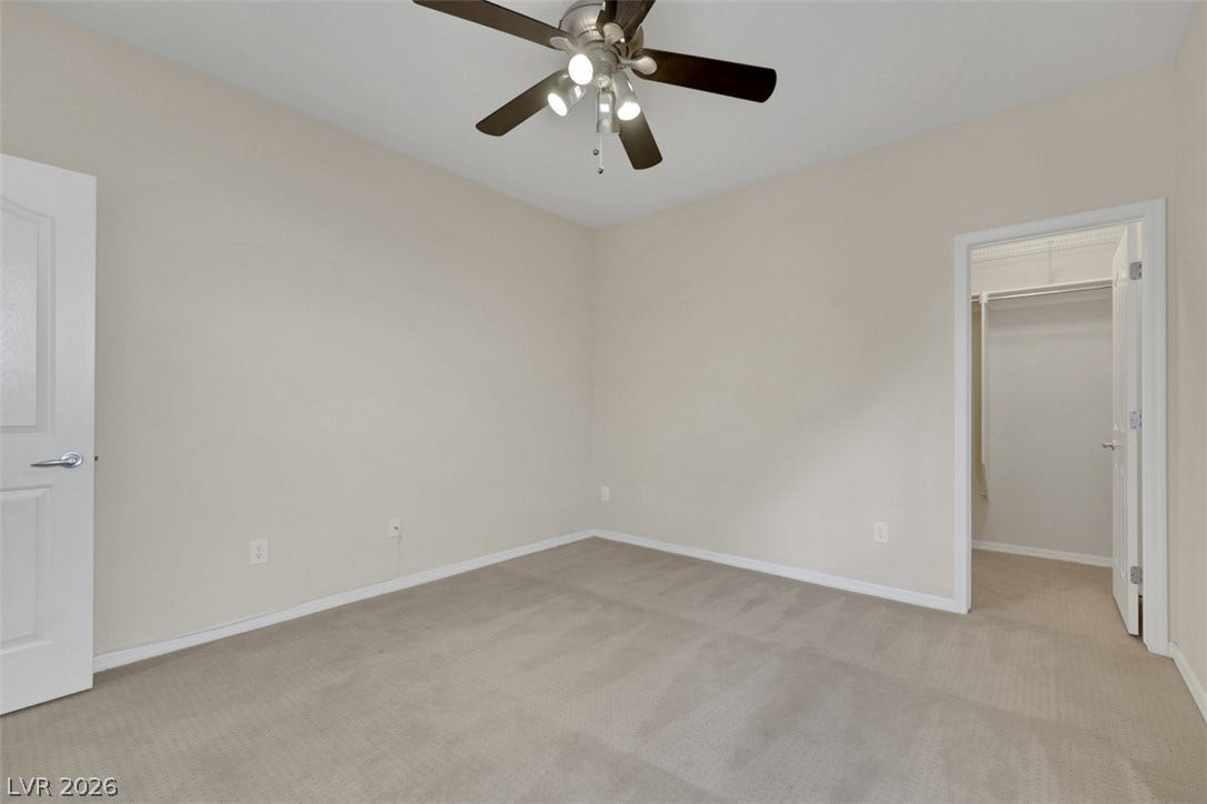 A well-lit bedroom with soft carpeting and a convenient walk-in closet.