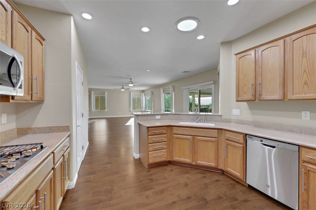 An open-concept kitchen seamlessly connects to the living area, offering wood flooring and abundant natural light.