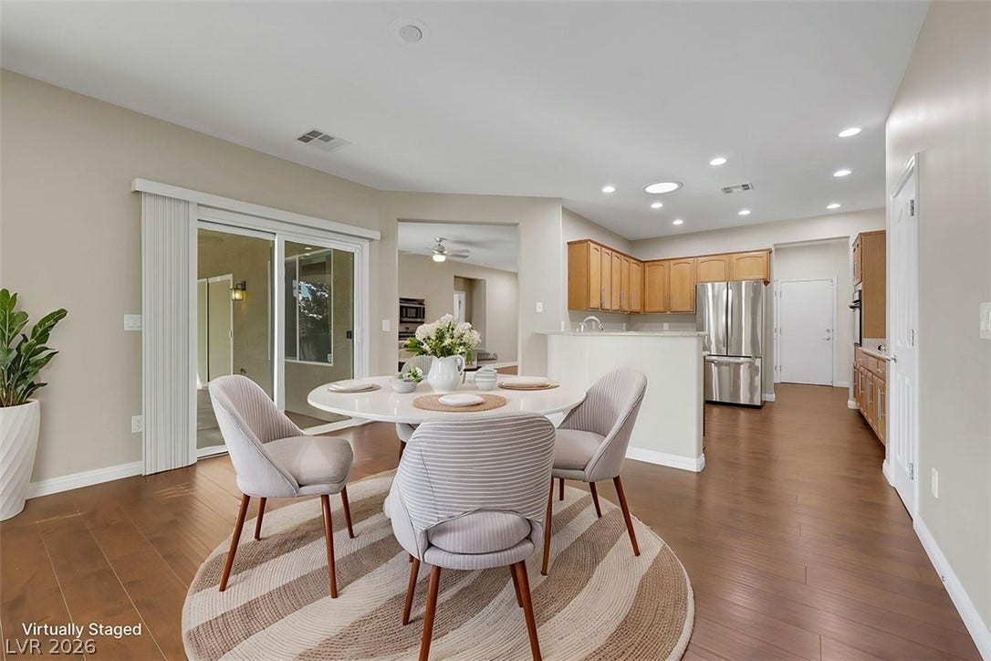 Wood flooring seamlessly connects the inviting dining area to the well-appointed kitchen.