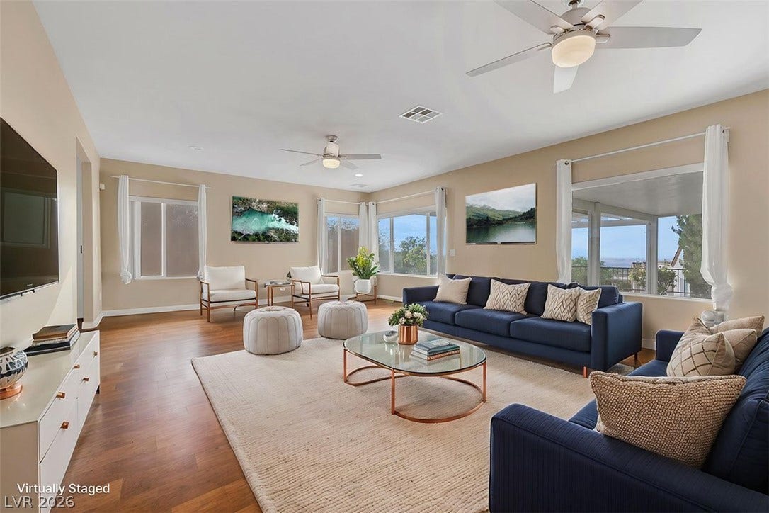 A naturally illuminated living area presents ample space for relaxation and entertaining, anchored by rich wood flooring.