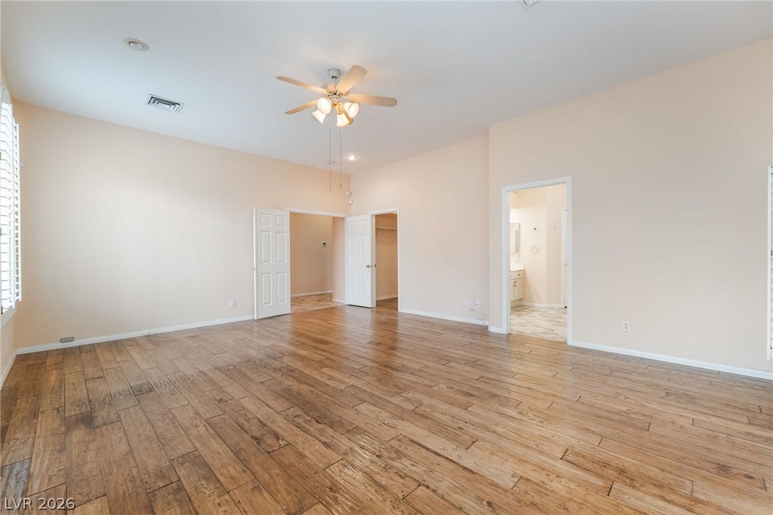 3775 Rick Stratton Drive, Las Vegas, NV 89120 A well-proportioned bedroom with rich wood flooring and ample natural light, ready for personalization.
