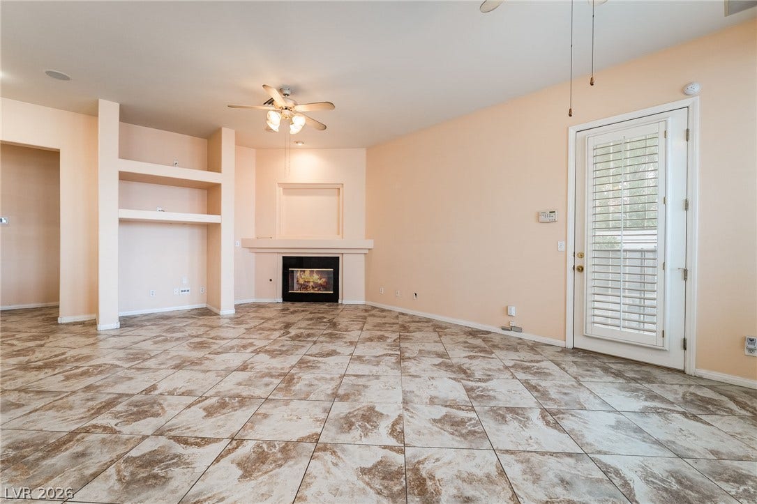 3775 Rick Stratton Drive, Las Vegas, NV 89120 A spacious living area with warm tile flooring and a cozy fireplace awaits.