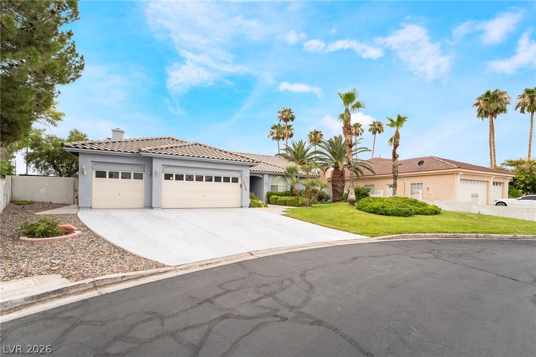 3775 Rick Stratton Drive, Las Vegas, NV 89120 A graceful home featuring an attached two-car garage and a manicured lawn under a vivid blue sky.