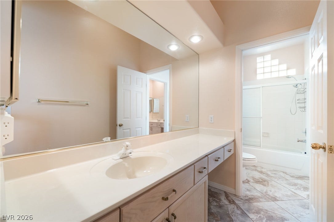 3775 Rick Stratton Drive, Las Vegas, NV 89120 A well-lit primary bathroom features an elongated vanity with extensive counter space and a clean shower/tub combination.