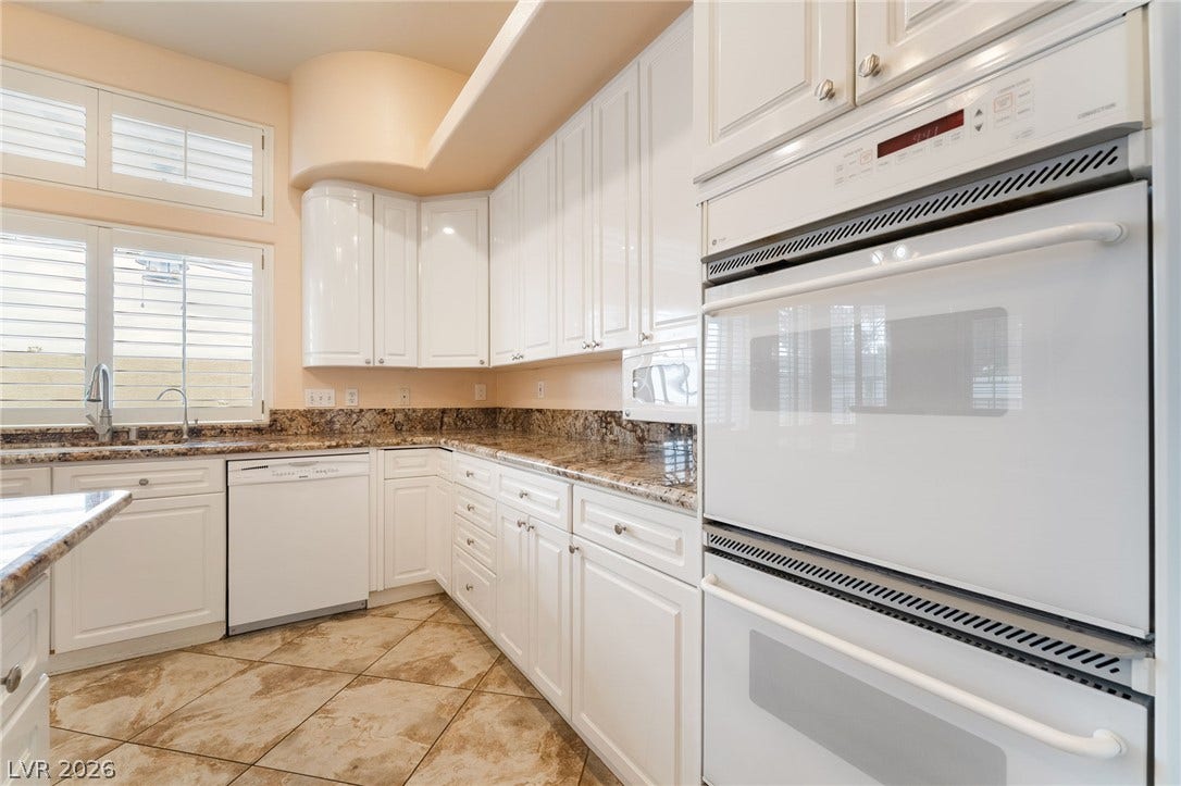 3775 Rick Stratton Drive, Las Vegas, NV 89120 White cabinetry, stone countertops, and tile flooring create an inviting kitchen space.
