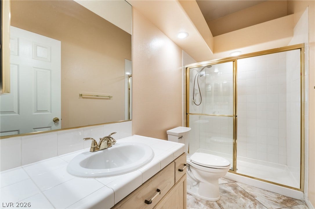 3775 Rick Stratton Drive, Las Vegas, NV 89120 Functional full bathroom with a tiled vanity and an enclosed shower stall for daily convenience.