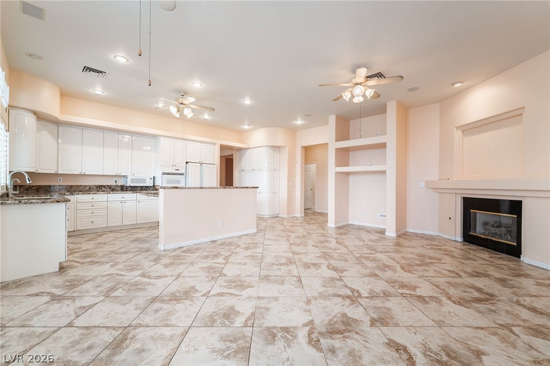 3775 Rick Stratton Drive, Las Vegas, NV 89120 An open-concept living area features a bright kitchen and a cozy fireplace, perfect for entertaining.