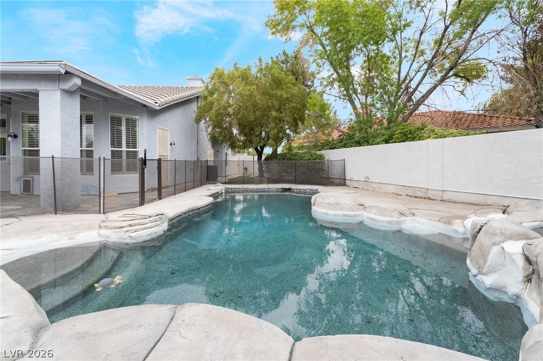 3775 Rick Stratton Drive, Las Vegas, NV 89120 A private swimming pool with unique rock accents offers a refreshing escape and serene backyard ambiance.