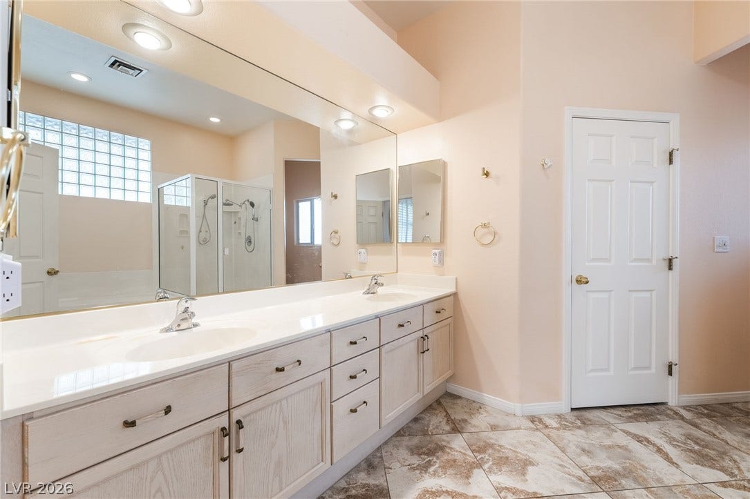 3775 Rick Stratton Drive, Las Vegas, NV 89120 Double vanity in this primary bathroom provides ample space for personal routines, complemented by a glass-enclosed shower.