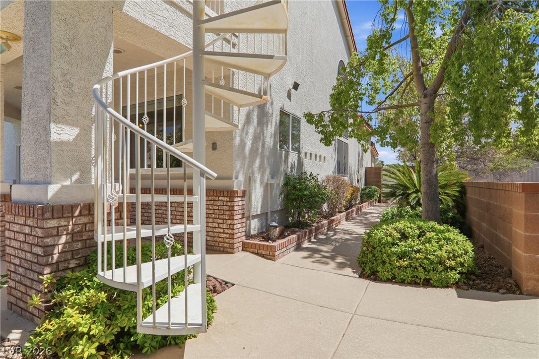 2218 Alanhurst Drive, Henderson, NV 89052 A striking spiral staircase accents the home's brick foundation and lush, manicured landscaping.