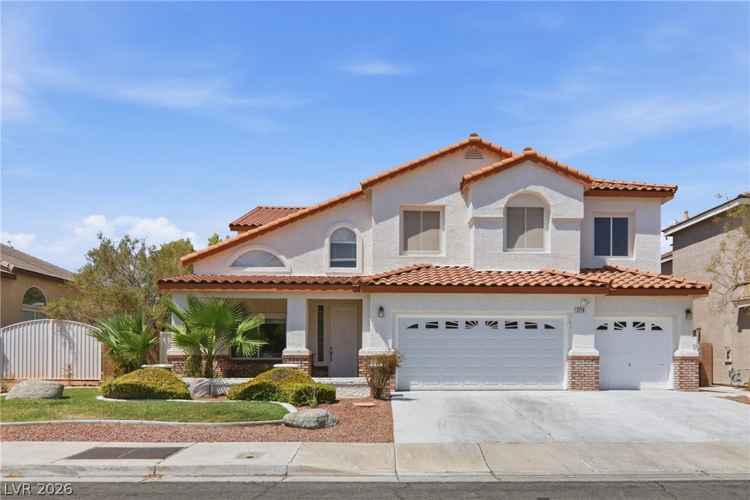 2218 Alanhurst Drive, Henderson, NV 89052 A well-maintained facade features a covered entry, an attached garage, and mature desert landscaping.