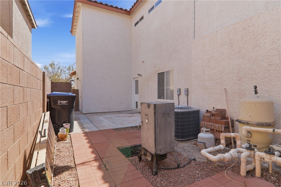 2218 Alanhurst Drive, Henderson, NV 89052 A compact outdoor area with a mix of paved and gravel surfaces, offering practical space for utilities and storage.