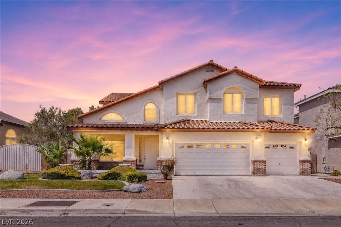 2218 Alanhurst Drive, Henderson, NV 89052 A striking stucco facade with a red tile roof creates a classic Mediterranean aesthetic under a vibrant sunset sky.