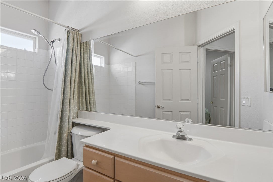 2218 Alanhurst Drive, Henderson, NV 89052 A bright bathroom with a shower-tub combo, a wide vanity, and a large mirror.