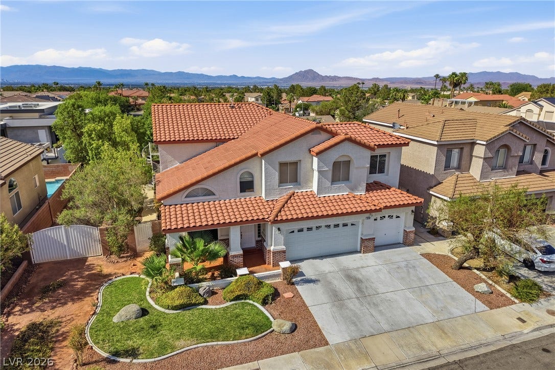 2218 Alanhurst Drive, Henderson, NV 89052 A terracotta-tiled roof crowns this residence with a well-maintained front lawn, framed by a concrete driveway.