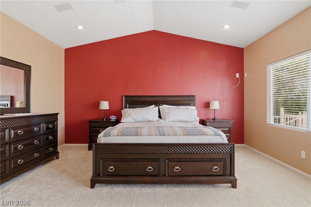 2218 Alanhurst Drive, Henderson, NV 89052 Vaulted ceilings and plush carpeting define this inviting bedroom, bathed in natural light from the large window.