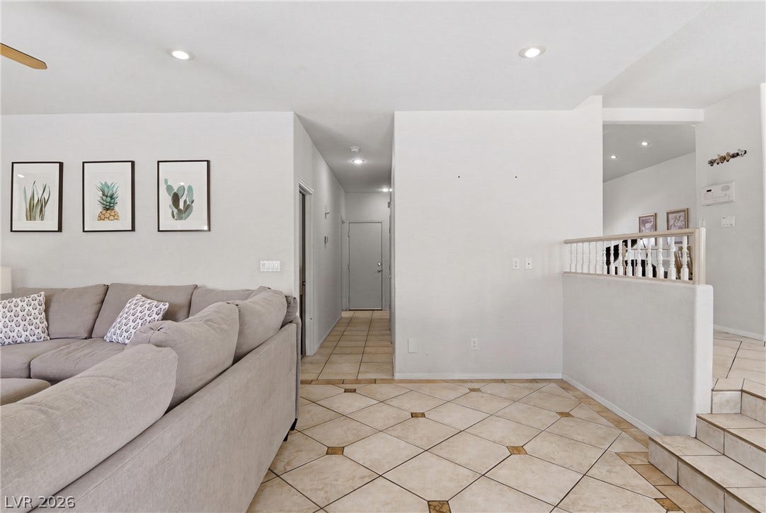 2218 Alanhurst Drive, Henderson, NV 89052 Clean lines and tiled flooring extend a welcoming ambiance throughout this living area, featuring recessed lighting and a classic white banister.