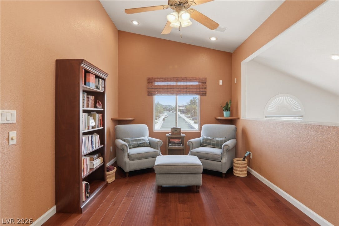 2218 Alanhurst Drive, Henderson, NV 89052 A quiet reading nook features soaring vaulted ceilings and polished hardwood flooring, ideal for a peaceful retreat.