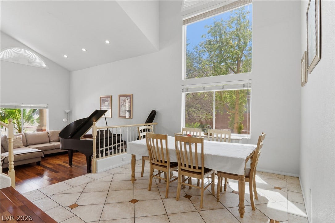 2218 Alanhurst Drive, Henderson, NV 89052 A spacious dining area seamlessly transitions into a living room, bathed in natural light.