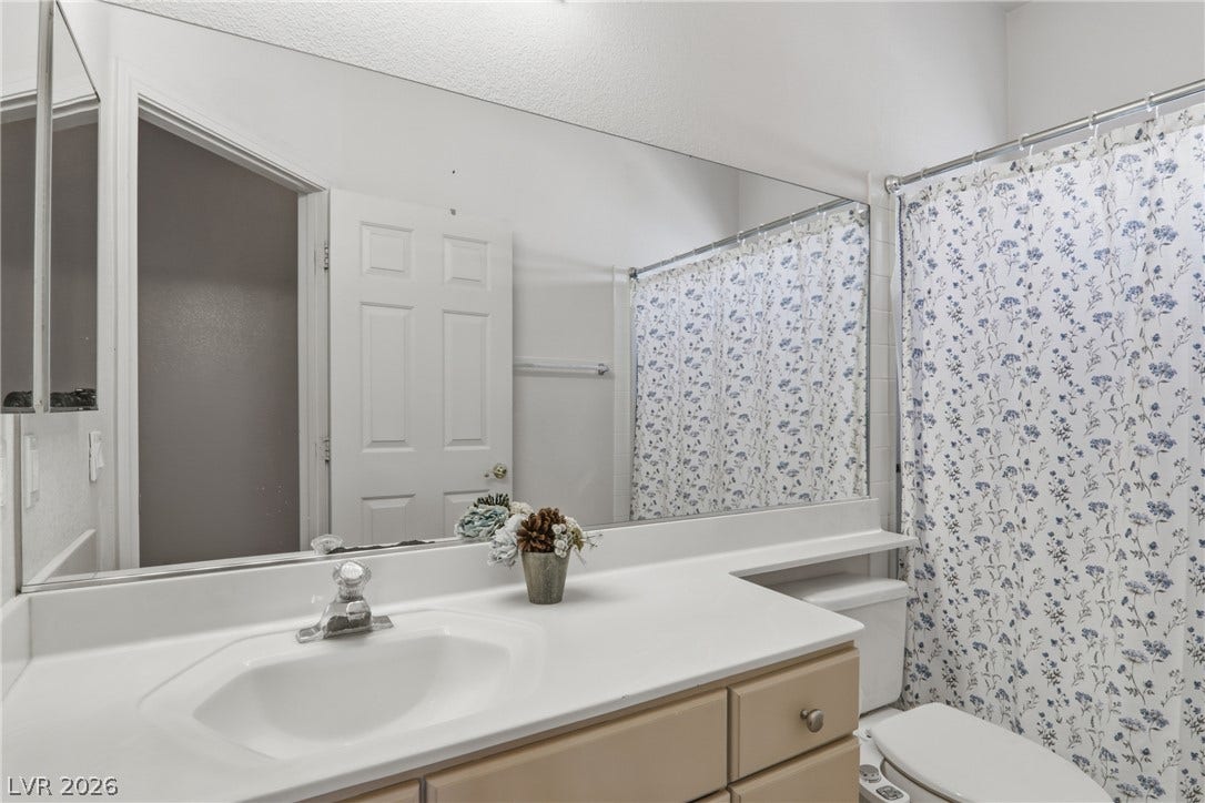2218 Alanhurst Drive, Henderson, NV 89052 A pristine bathroom features a single vanity, sleek white countertops, and an integrated sink.