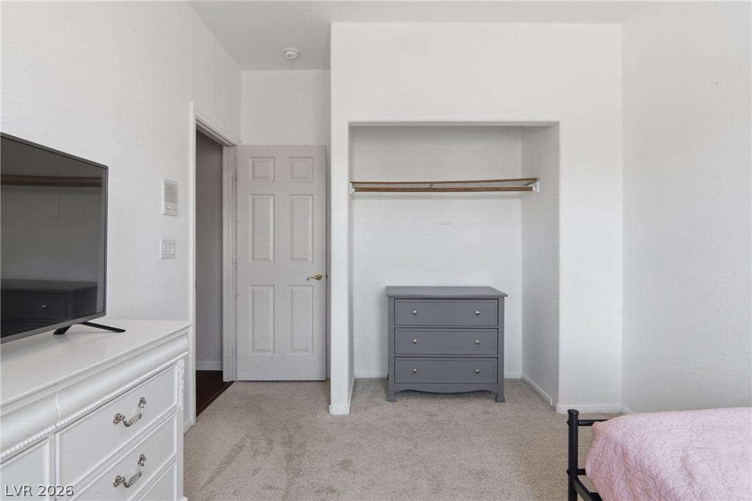 2218 Alanhurst Drive, Henderson, NV 89052 A well-lit bedroom offering plush carpeting and a convenient open closet space.