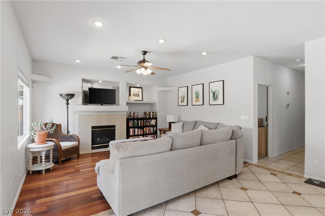 2218 Alanhurst Drive, Henderson, NV 89052 A welcoming living area boasts rich hardwood and tile flooring, a cozy fireplace, and recessed lighting.