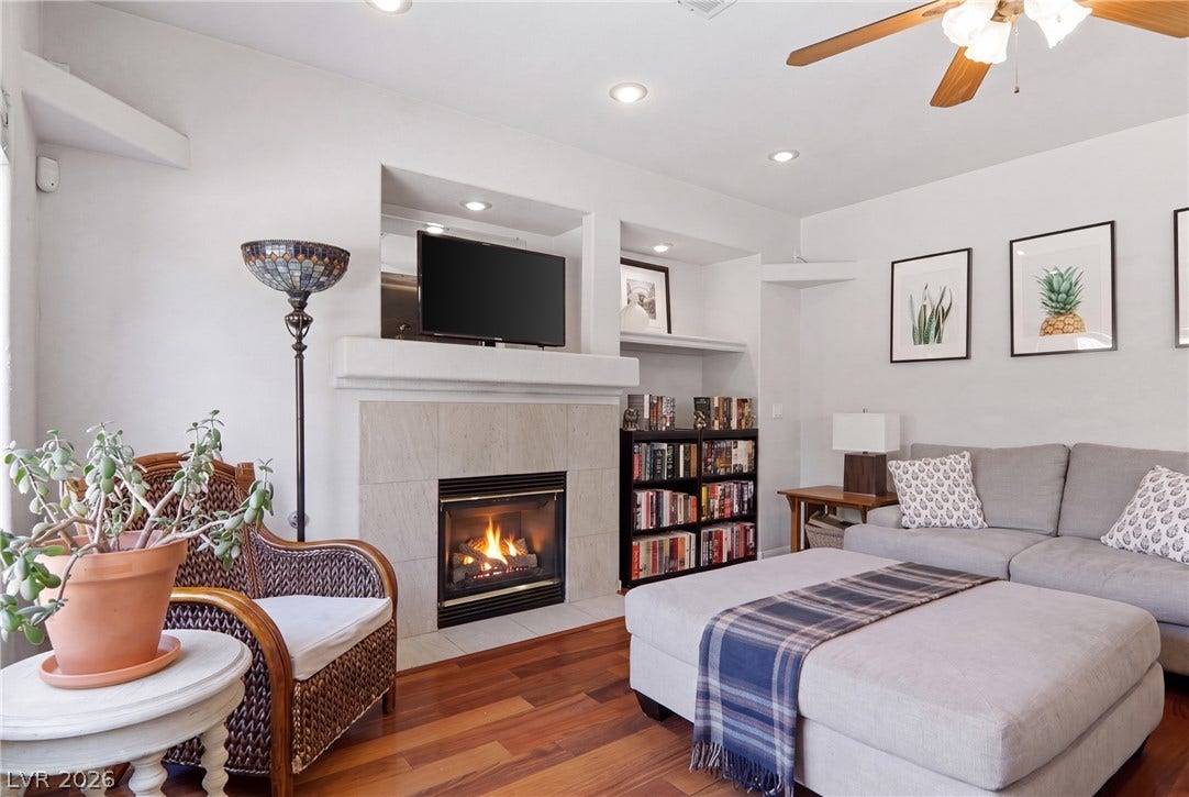2218 Alanhurst Drive, Henderson, NV 89052 A comforting living space features rich wood flooring, a warm fireplace, and clever built-in shelving.