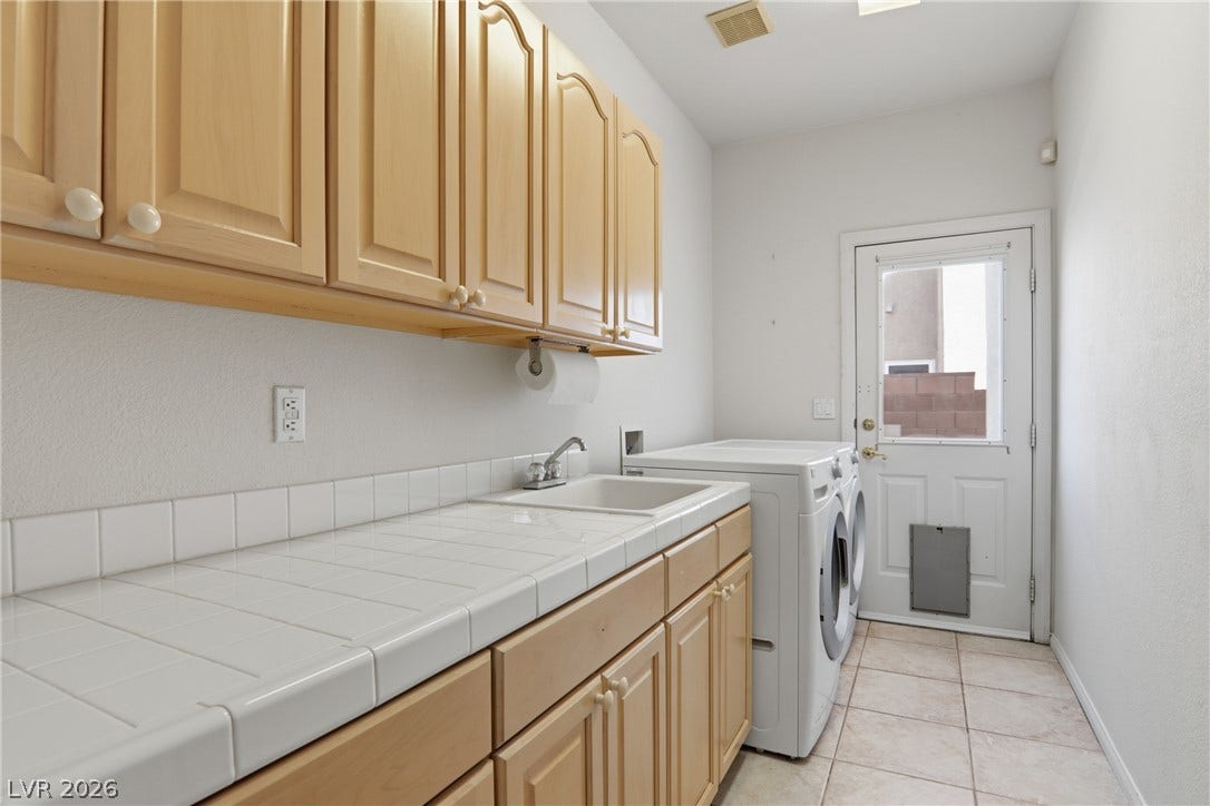 2218 Alanhurst Drive, Henderson, NV 89052 Functional laundry room offers a built-in utility sink, abundant cabinetry, and convenient outdoor access.