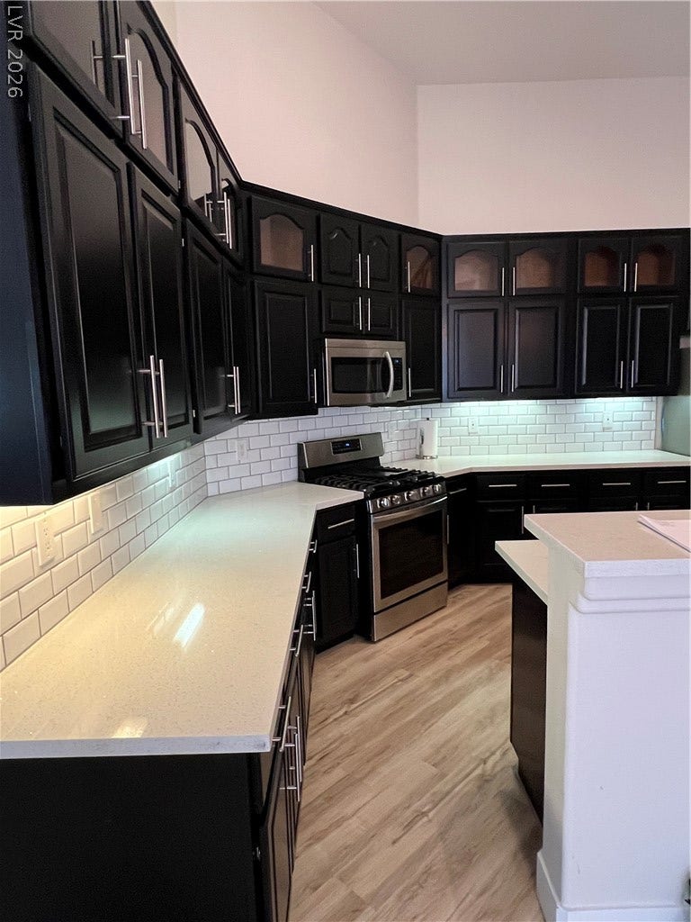 9621 Dancing Pond Way, Las Vegas, NV 89178 Modern kitchen with sleek dark cabinetry and luminous countertops, perfect for culinary endeavors.