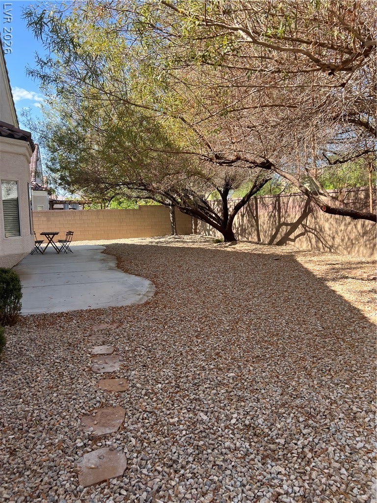 9621 Dancing Pond Way, Las Vegas, NV 89178 A tranquil backyard retreat features natural rock landscaping and mature shade trees.