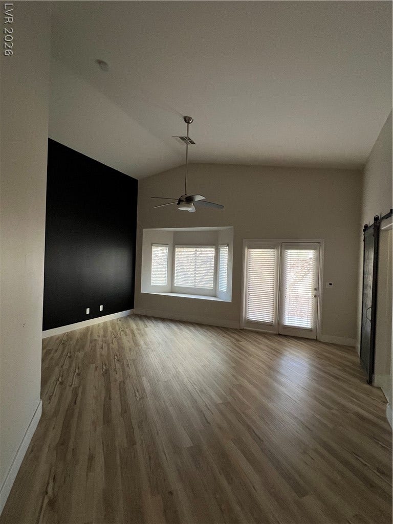 9621 Dancing Pond Way, Las Vegas, NV 89178 A living space offers generous height with a modern ceiling fan and natural light from tall windows.