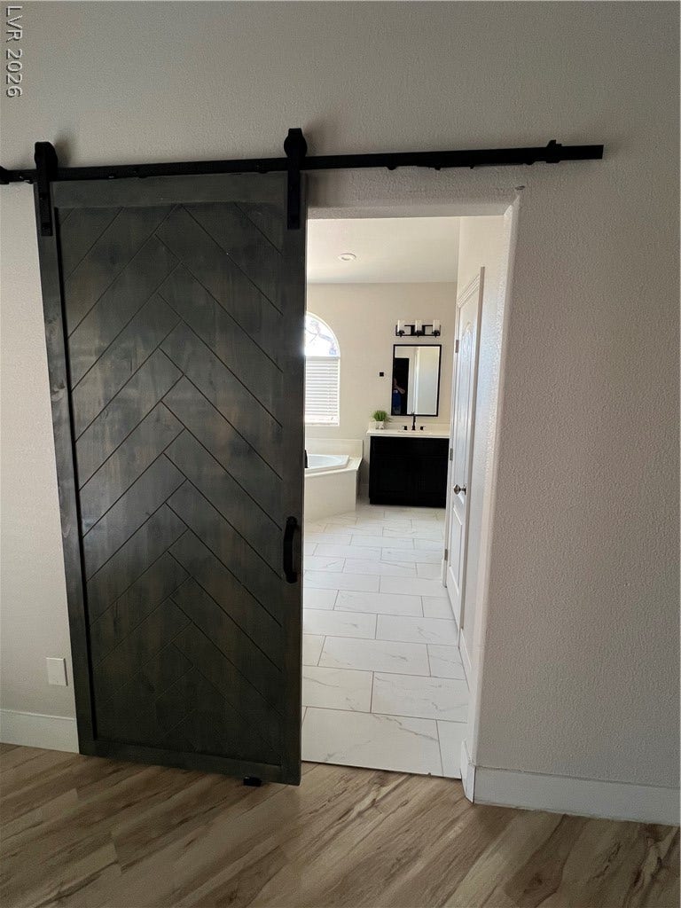 9621 Dancing Pond Way, Las Vegas, NV 89178 A stylish barn door slides open to reveal a bathroom featuring elegant tile flooring.