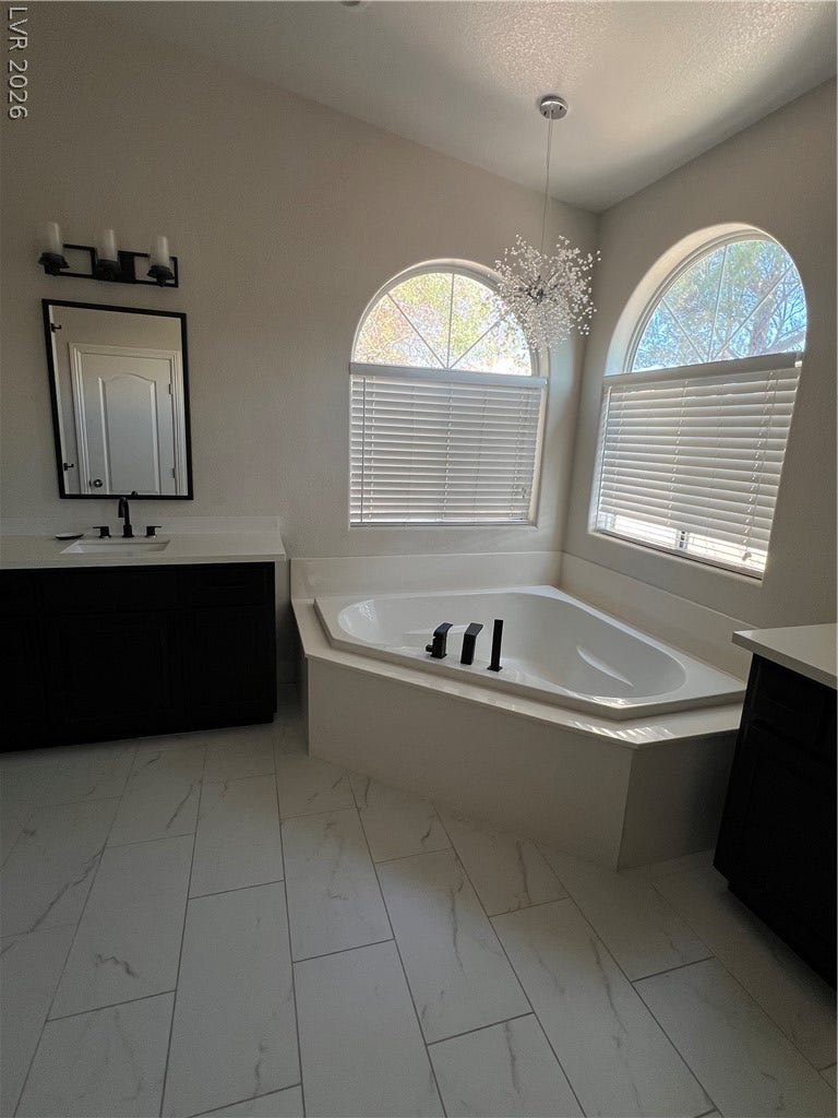 9621 Dancing Pond Way, Las Vegas, NV 89178 Luxurious soaking tub and elegant tile work define this private bath retreat.