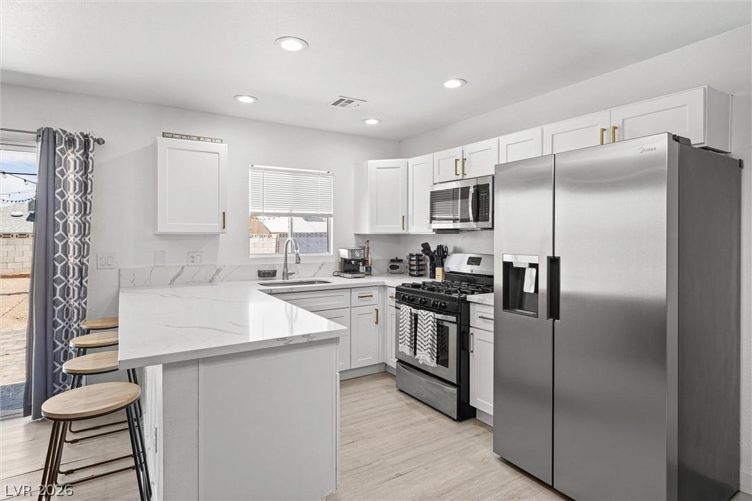 525 Van Dornum Avenue, Henderson, NV 89011 A well-lit kitchen featuring stainless steel appliances and ample counter space, ideal for culinary creations.