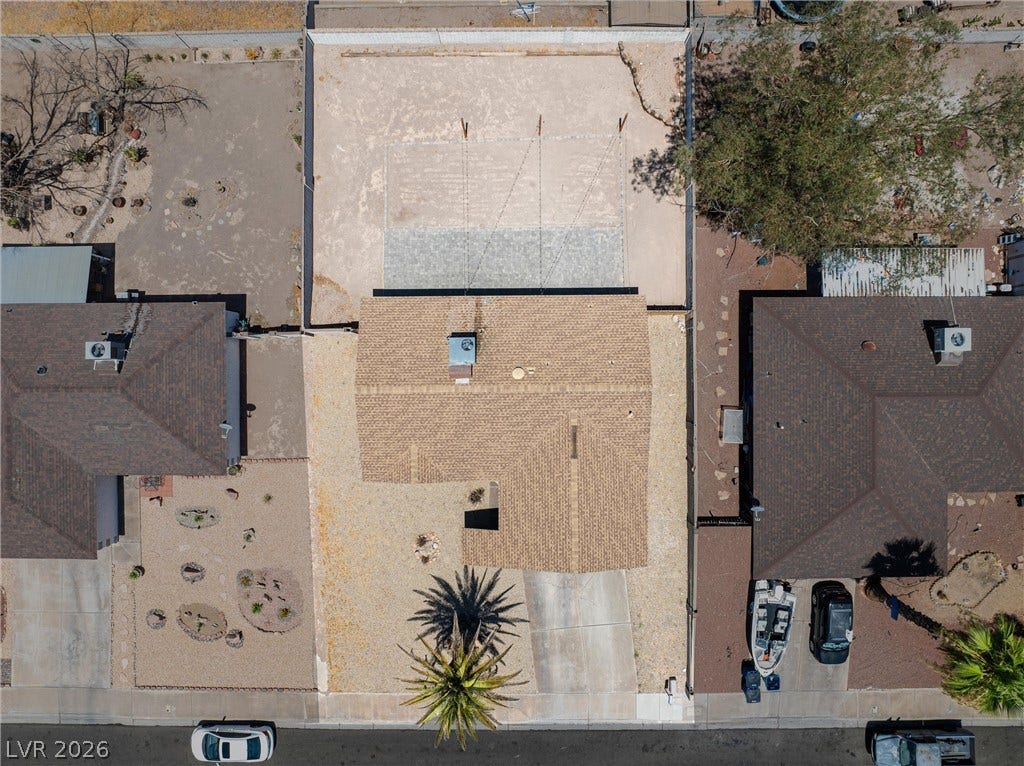 525 Van Dornum Avenue, Henderson, NV 89011 An aerial perspective reveals a residence with an attached paved driveway, a well-defined roofline, and an integrated sports court.