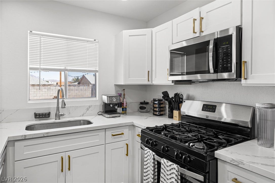 525 Van Dornum Avenue, Henderson, NV 89011 A well-appointed kitchen features ample white cabinetry, gleaming countertops, and modern stainless steel appliances.