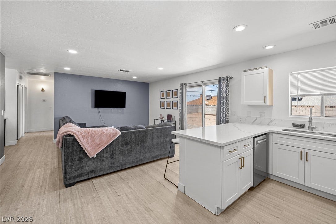525 Van Dornum Avenue, Henderson, NV 89011 An open-concept living space integrates a modern kitchen island with a sunlit lounge area.