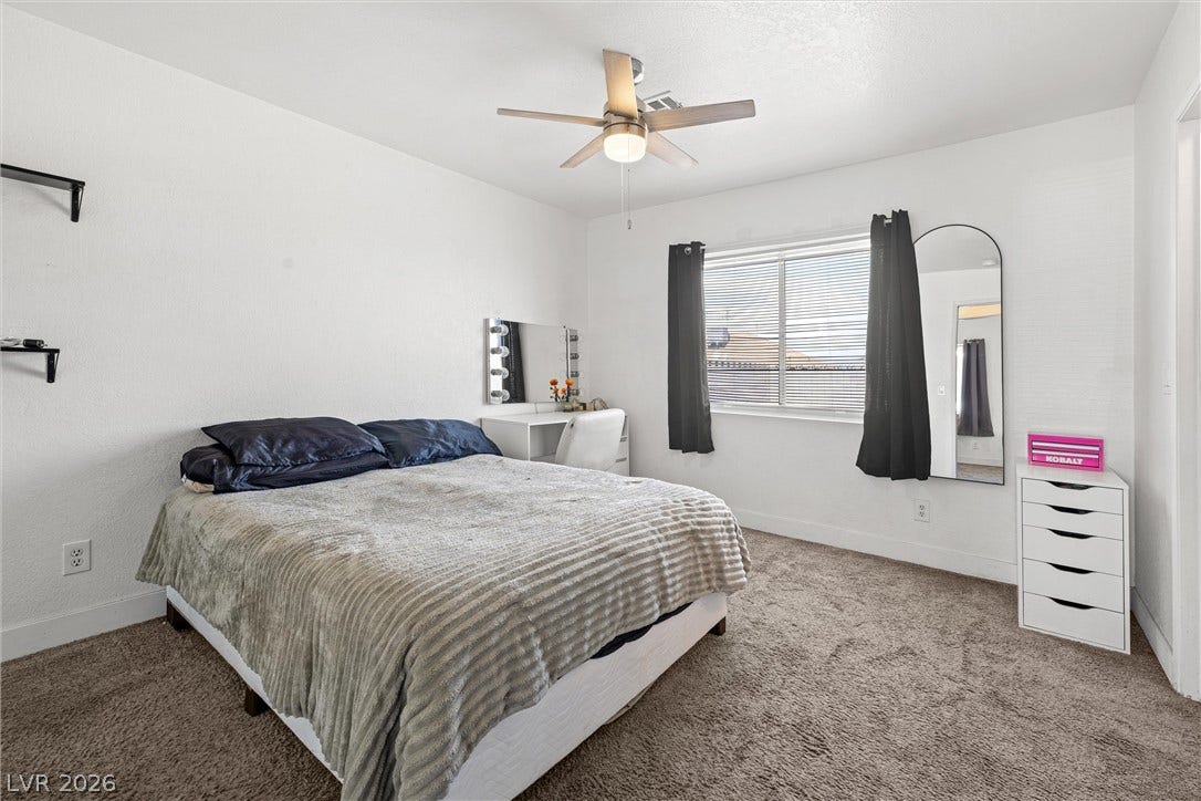 525 Van Dornum Avenue, Henderson, NV 89011 A comfortable bedroom features plush carpet and a ceiling fan for year-round comfort.