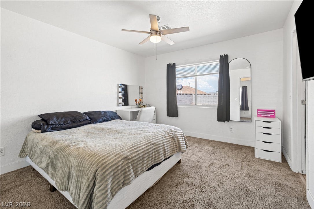 525 Van Dornum Avenue, Henderson, NV 89011 A well-lit bedroom provides comfortable living space with plush carpeting and a modern ceiling fan.