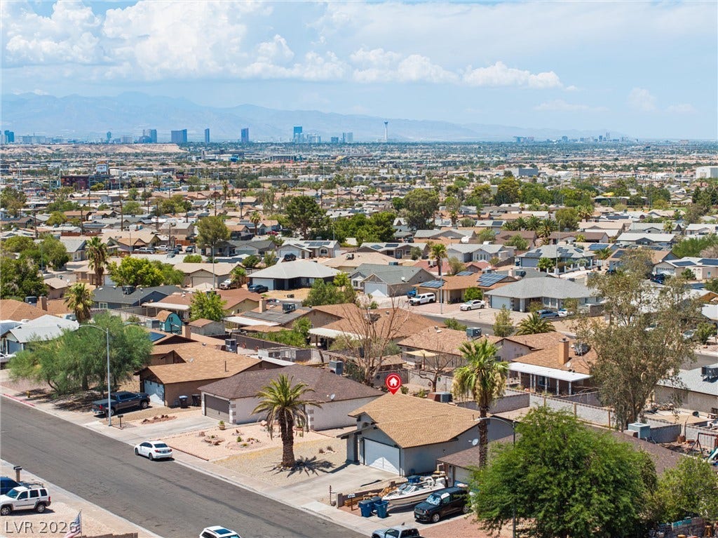 525 Van Dornum Avenue, Henderson, NV 89011 An aerial perspective showcases a residential neighborhood with desert landscaping and a distant cityscape.