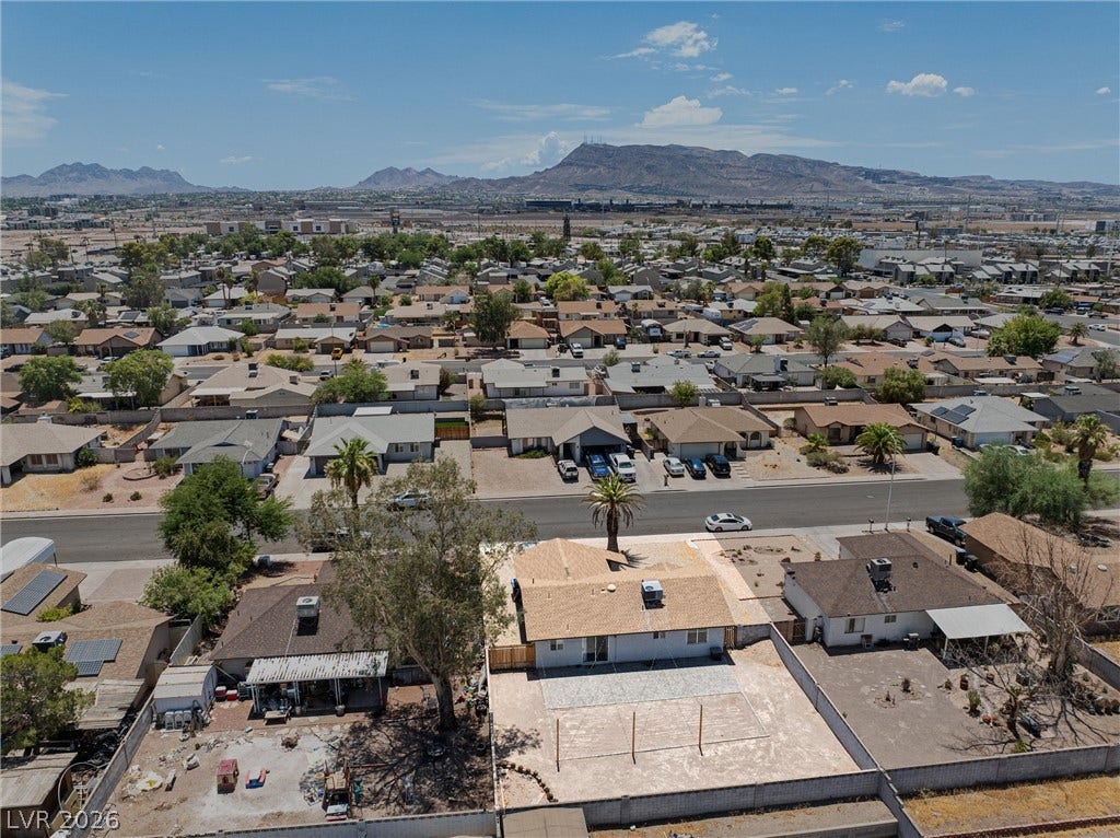 525 Van Dornum Avenue, Henderson, NV 89011 An aerial perspective reveals a residential community nestled against a distant mountainous backdrop.